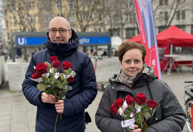 Mirjam Golm und Ruppert Stüwe halten am Weltfrauentag Rosen in der Hand
