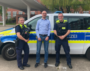 Ruppert Stüwe mit einer Polizistin und einem Polizisten
