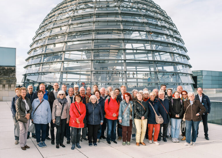 Ruppert Stüwe mit einer Besuchergruppe vor der Kuppe des Deutschen Bundestages