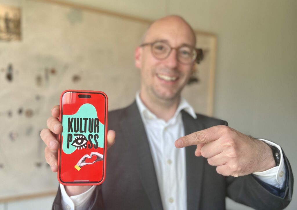 Ruppert Stüwe deutet auf sein Handy