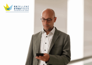 Ruppert Stüwe blickt auf sein Handy